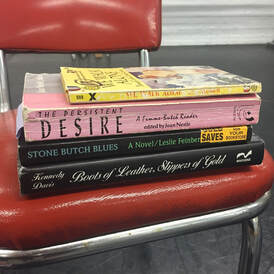 photo shows four books stacked on a red chair: 